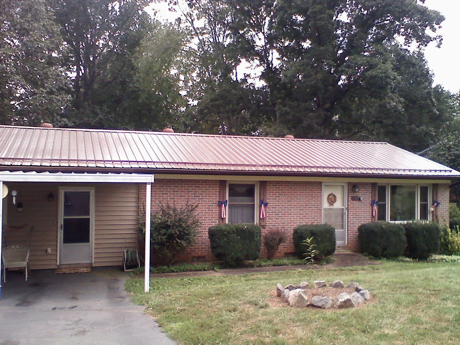 Bronze metal roof and carport on a brick ranch home — Roof Repair work by our crew in Carmel